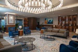 a lobby with couches and chairs and a chandelier at Radisson Blu Hotel, Amman Galleria Mall in Amman