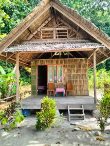 Cabaña pequeña con sillas y mesa en Raja Ampat Diva homestay, en Waisai