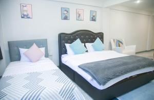 1 dormitorio con 2 camas y almohadas blancas y azules en OYO 75457 Hello Host en Chiang Mai