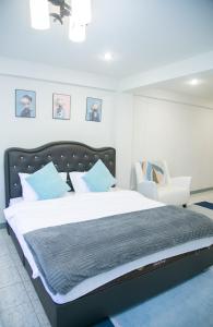 1 dormitorio con 1 cama grande y 1 silla blanca en OYO 75457 Hello Host en Chiang Mai