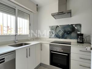 a white kitchen with a sink and a stove at Moderno apartamento a pocos metros de la playa 126A - INMO22 in Cambrils