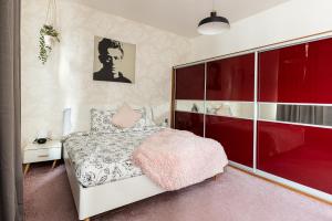 a bedroom with a white bed with a pink blanket at Nice big apartment 2bds - Belgicka in Prague