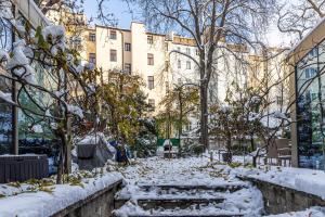 a snow covered street in front of a building at Nice big apartment 2bds - Belgicka in Prague