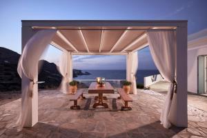 einen Pavillon mit einem Tisch und Meerblick in der Unterkunft Villa Imperial Milos in Mandrakia