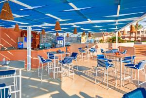 restauracja z niebieskimi sufitami, stołami i krzesłami w obiekcie Pickalbatros Sands Port Ghalib w mieście Port Ghalib