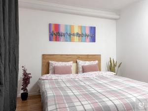 a bedroom with a bed and a painting on the wall at Renthouse Apartments City Gates #2 in Chişinău