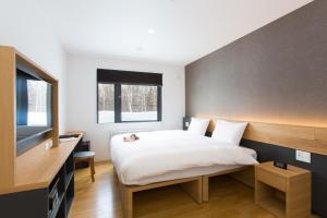 a bedroom with a bed and a television at Always Niseko in Niseko