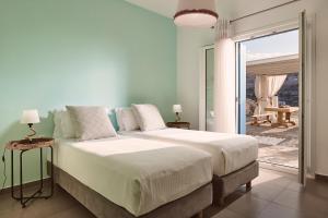 ein Schlafzimmer mit einem Bett und einer Glasschiebetür in der Unterkunft Villa Imperial Milos in Mandrakia + 35 Fotos