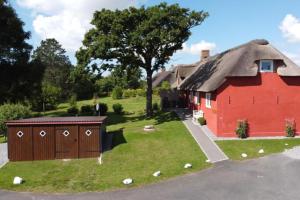 une grange rouge avec un toit de chaume dans l'établissement Haus Hanna, à Dagebüll