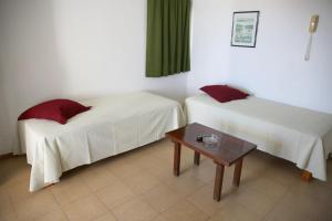 a hotel room with two beds and a table at Apartamentos Mar y Sal in La Savina