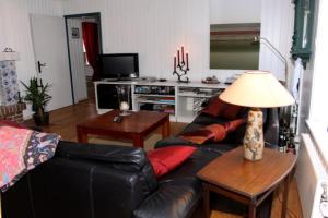 uma sala de estar com um sofá de couro preto e uma mesa em Haus Holländerdeich em Dagebüll