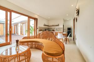 ein Wohnzimmer mit einer Rattanbank und einem Tisch in der Unterkunft Diana ArtVilla by ArthouseBali in Canggu