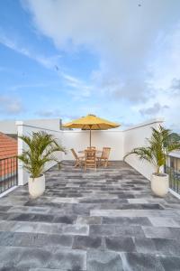 eine Terrasse mit einem Tisch und einem Sonnenschirm auf dem Dach in der Unterkunft Diana ArtVilla by ArthouseBali in Canggu