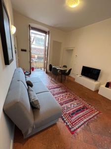 een woonkamer met een bank en een televisie bij Nur 1 Casa Vacanze Bergamo in Bergamo