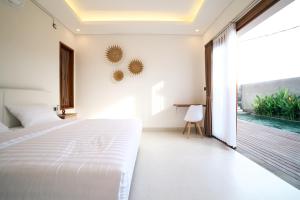 ein Schlafzimmer mit einem weißen Bett und einem großen Fenster in der Unterkunft Diana ArtVilla by ArthouseBali in Canggu + 13 Fotos