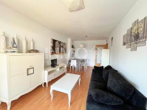 a living room with a couch and a table at Apartamento con piscina y parking en edif Las Dunas 154B - INMO22 in Cambrils
