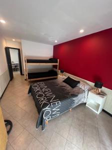 1 dormitorio con cama y pared roja en Ohana Apart en Mar del Plata