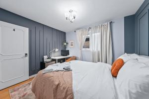 Large & Sunny Private bedroom in Villa في تورونتو: غرفة نوم بجدران زرقاء وسرير مع وسادة برتقال