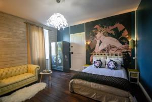 - une chambre avec un lit et une peinture murale dans l'établissement Mas des 2 paons, à Villedaigne