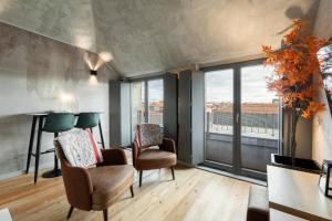 uma sala de estar com duas cadeiras e uma grande janela em GuestReady - Elegant living in Porto city centre no Porto