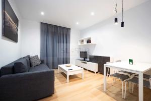 a living room with a couch and a table at Asturches Apartamento in Gijón