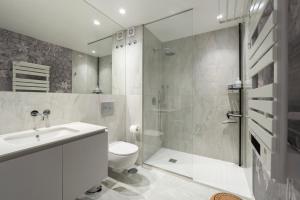 uma casa de banho com um WC, um lavatório e um chuveiro em GuestReady - Elegant living in Porto city centre no Porto