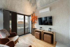 uma sala de estar com um sofá e uma televisão na parede em GuestReady - Elegant living in Porto city centre no Porto