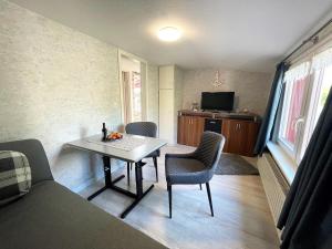 una pequeña sala de estar con mesa y sillas. en Hundeurlaub bei Karin, Holzhaus, eingezäunter Garten, E-Ladestation, WLAN, ebenerdig, en Emmelsbüll-Horsbüll