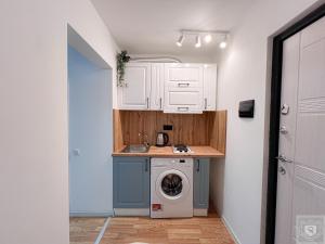 a kitchen with a washing machine and a sink at Renthouse Apartments City Gates #2 in Chişinău