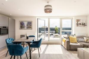a living room with a table and a couch at Finsbury Park Penthouse: Luxe City Living in London