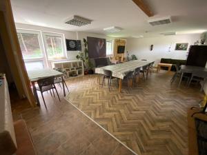 a room with tables and chairs on a wooden floor at Chata Trojanovice in Trojanovice