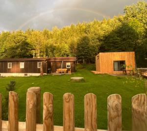 a rainbow over a backyard with a house and a fence at Chata Trojanovice in Trojanovice