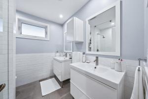 a white bathroom with a sink and a mirror at Large & Sunny Private bedroom in Villa in Toronto