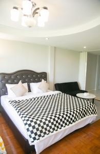 1 cama con manta a cuadros en blanco y negro en OYO 75457 Hello Host en Chiang Mai