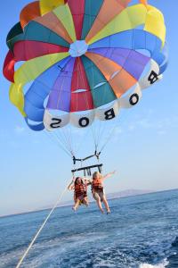 two people are falling from a parachute in the water at Regency Plaza Aqua Park and Spa Resort in Sharm El Sheikh
