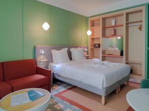 a bedroom with a bed and a red chair at Aparthotel AMMI Nice Lafayette in Nice