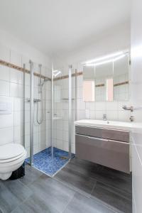 a bathroom with a shower and a toilet and a sink at Haus Bendix in Dagebüll