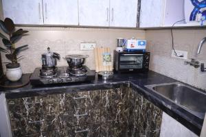 uma cozinha com um lavatório, um fogão e um micro-ondas em Fortune Home Service Apartment 1Bhk,L-36B,Saket em Nova Deli