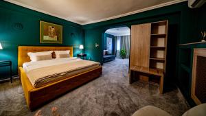 a bedroom with a bed and a green wall at Hotel Cocó in Timişoara