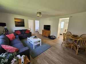ein Wohnzimmer mit einem Sofa und einem Tisch in der Unterkunft Pet Friendly 2 Bed Coastal Property - Millendreath, Looe in Looe