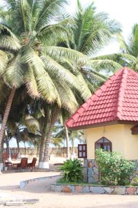 un complexe avec des palmiers et un bâtiment dans l'établissement Rent your own private beach bungalow, à Ampeni