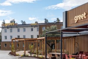 a rendering of the front of a hotel with tables and chairs at Greet hotel Bourg-en-Bresse Sud Montagnat in Montagnat