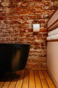 a bathroom with a toilet and a brick wall at Kleinstes Haus Deutschlands in Bremen