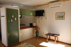 a living room with a green door and a kitchen at Apartamentos Mar y Sal in La Savina