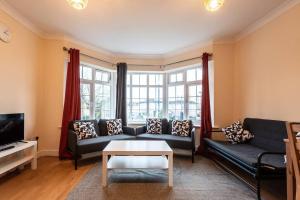 uma sala de estar com um sofá e uma televisão em Comfy - 3 Bedroom Flat With Parking em Southampton