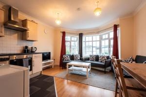 a kitchen and living room with a couch and a table at Comfy - 3 Bedroom Flat With Parking in Southampton