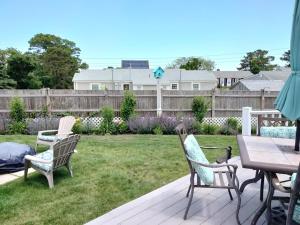 a patio with chairs and a table and a yard at Sandtrap Cape Cod in West Yarmouth