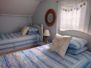 a bedroom with two twin beds and a mirror at Sandtrap Cape Cod in West Yarmouth