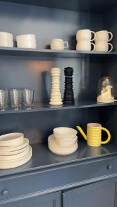 a shelf filled with plates and cups and bowls at Le Clos Du Moulin 2 - Maison et jardin, proche Avignon, en Provence in Entraigues-sur-la-Sorgue