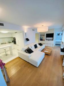 ein Wohnzimmer mit einem weißen Sofa und einem Tisch in der Unterkunft Residence Carlton Riviera in Cannes